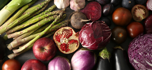 Various fresh vegetables with fruits on dark background