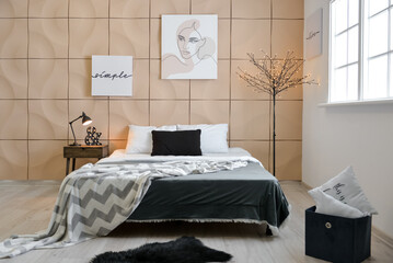 Interior of stylish bedroom with posters and glowing lamps