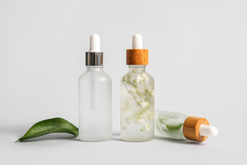 Fototapeta na wymiar Bottles of natural serum on white background