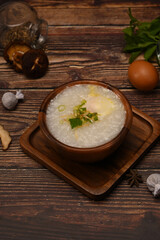 Congee, rice porridge or rice gruel with soft boiled egg, slice ginger and slice scallion topping for breakfast