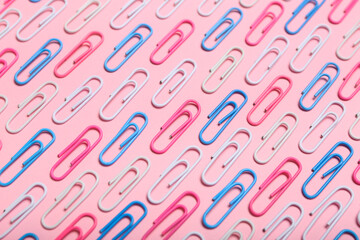 Colorful paper clips on pink background
