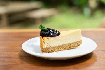 Piece of cheesecaket and blueberry sauce on white plate