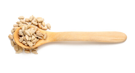 Wooden spoon and peeled sunflower seeds on white background