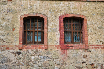 old wooden window with a red and white wall. Twin windows ancient and retro stone made.