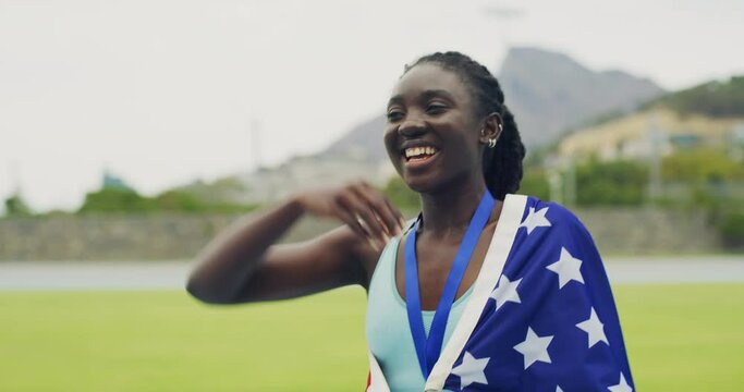 Proud and patriotic athlete becoming a champion. Olympic gold medalist cheering and biting her medal after winning a race. Black woman celebrating a victory while wearing the USA flag on her back.