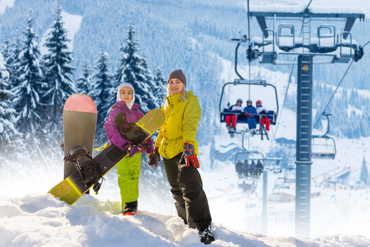 Family And Snowboard On Snowy Mountain