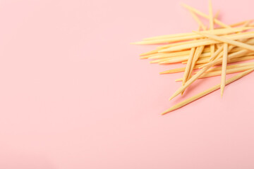 Heap of wooden toothpicks on pink background