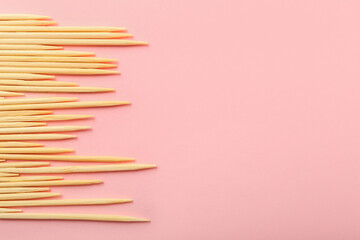 Wooden toothpicks on pink background, closeup