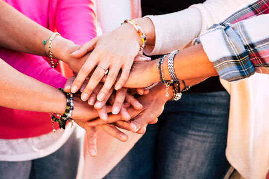 Close up of group of hands holding and stacking together in team friendship gesture concept. Women caucasian hands cooperate. Friends and teamwork image lifestyle. Accessories and fashion trendy