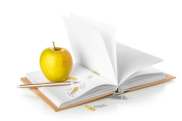 Book with apple, pen and paper clips on white background