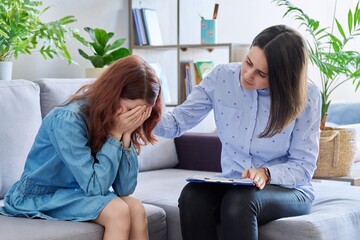 Female professional child psychologist working with preteen girl in office - obrazy, fototapety, plakaty