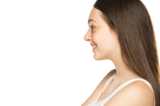 Profile portrait of smiling teenage girl on a white background