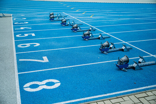 Running background. Start line with big numbers, athletics track and starting blocks. Blue colors