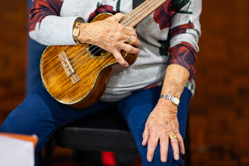 senior ukulele player resting holding ukulele