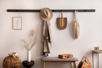 The stylish composition of cosy entryway with wooden basket, carpet, hanger and personal...