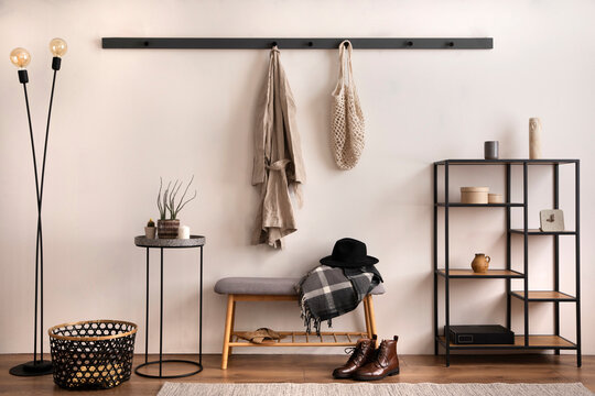The Stylish Composition Of Cosy Entryway With Grey Bench, Black Consola, Hanger And Lamp. Beige Wall. Home Decor. Template.
