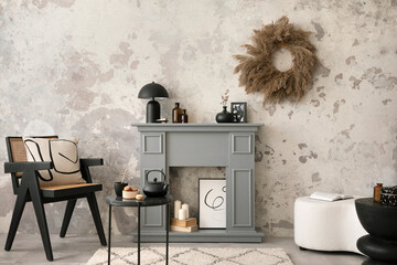 The stylish living room interior with grey fireplace, rattan armchair, concrete wall and dried flowers. Grey floor with beige carpet. Home decor. Template.