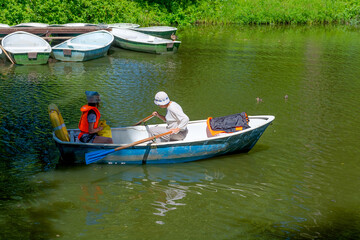 Obraz premium An elderly woman with a child is sailing on a boat in the summer . They have a good time on vacation. 