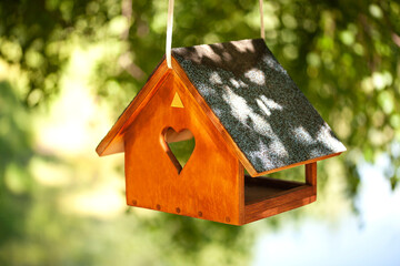 Birdhouses and bird feeder in the forest on a blurry background of greenery. Save birds. Bird...