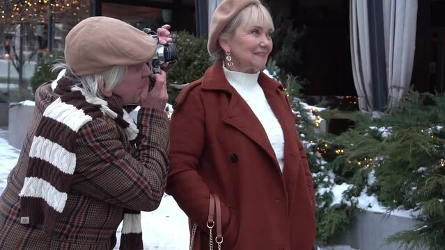 Beautiful senior couple on a walk in city center and making photo