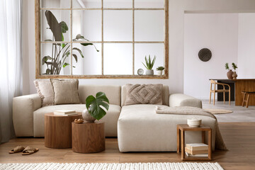 Modern interior of open space with design modular sofa, wooden coffee tables, plants and elegant personal accessories in stylish home decor. Neutral living room. Template.