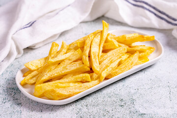 Fried potatoes. French fries on stone background. French fries served on a plate. close up