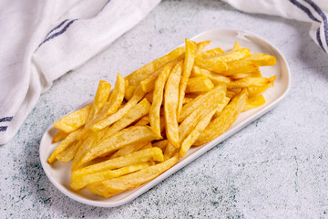 Fried potatoes. French fries on stone background. French fries served on a plate. close up