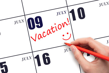 A hand writing a VACATION text and drawing a smiling face on a calendar date 9July. Vacation planning concept.