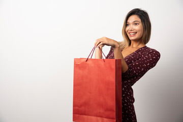 Fototapeta na wymiar Young woman showing shopping bag on white background