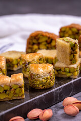 Varieties of pistachio baklava. Varieties of baklava on a dark background. Traditional Turkish cuisine delicacies. Desserts with pistachio syrup in the middle. close up