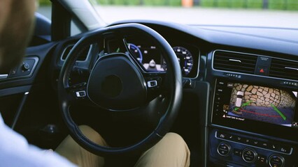 Self Driving Autopilot Autonomous Cars. Male driver parking electric car which is driven automatically. Man driving in innovative automated car using self-parking autopilot for parking on parking lot.