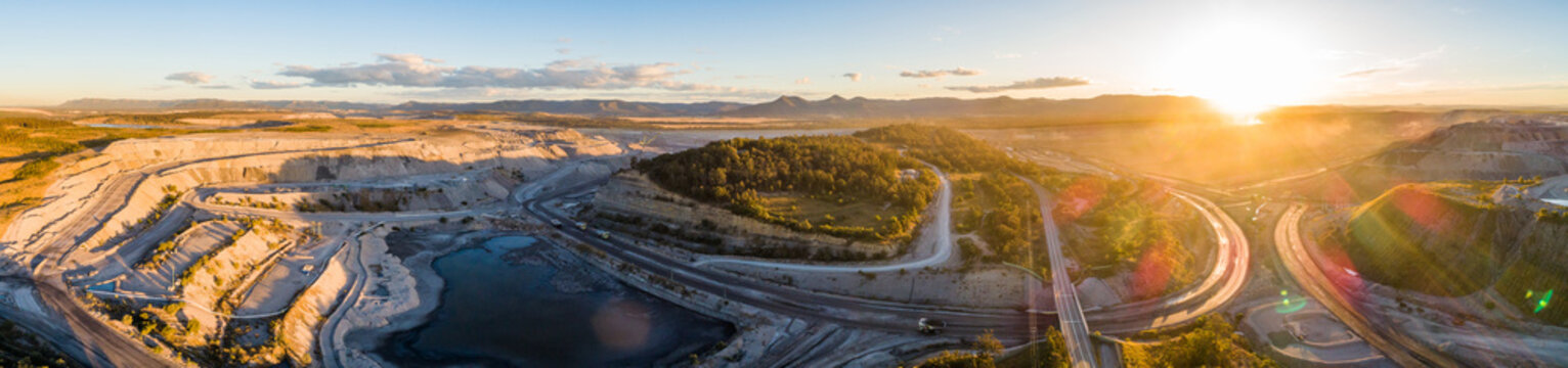 Panoramic aerial view of open cut coal mines surrounding road in Singleton area