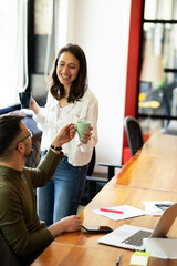 Colleagues in office. Businesswoman and businessman drinking coffee.