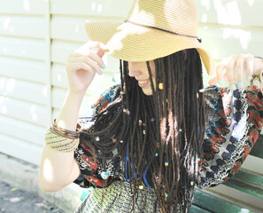 Beautiful woman portrait with dreadlocks dressed in boho style dress and necklace