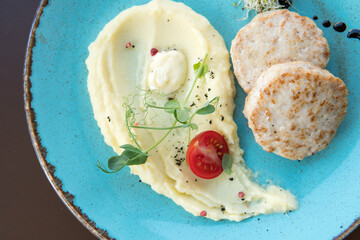 Mashed potatoes with beef patty and tomato