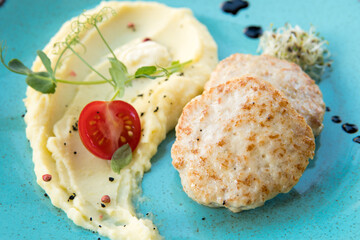 Mashed potatoes with beef patty and tomato