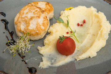 Mashed potatoes with beef patty and tomato