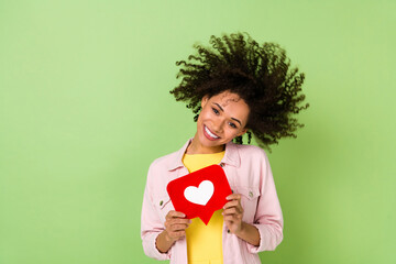 Photo of charming cheerful girl hold paper like card toothy smile look camera isolated on green...