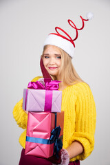 Blonde woman in Santa hat holding Christmas gifts