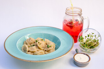 Dumplings with meat, sour cream, microgreens