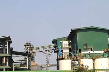 Fototapeta premium Factory structure for agricultural food production such as rice and corn for processing for consumers and consumption that is adjacent to the river as a business for exporting and selling in Thailand