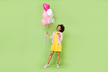 Full body portrait of lovely girl hand chest look balloons wear short mini dress isolated on green color background