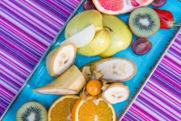 Fototapeta na wymiar Healthy fresh fruit salad in glass bowl on white wooden background