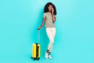 Full size portrait of charming person hold speak telephone suitcase isolated on bright cyan color background