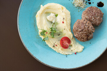 Mashed potatoes with beef patty and tomato