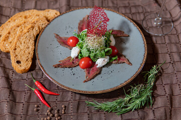 Meat salad with cured breast and mozzarella, tomatoes, herbs and chiabatta
