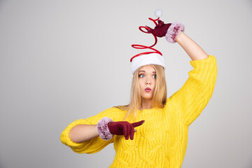 Beautiful girl in a yellow sweater and Santa's hat posing