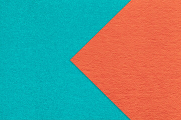 Fototapeta premium Texture of cyan and orange paper background, half two colors with arrow, macro. Structure of cerulean cardboard.