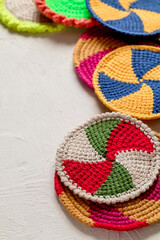 Many round spiral cup coasters with tunisian crochet on a white background. Handmade home decor.