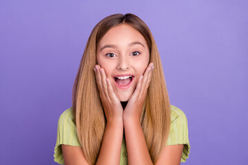 Portrait of astonished positive girl arms touch cheekbones open mouth isolated on purple color background
